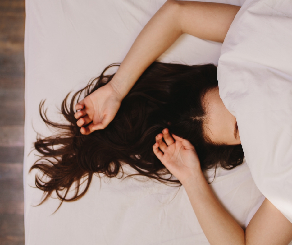 a woman in bed with her face covered